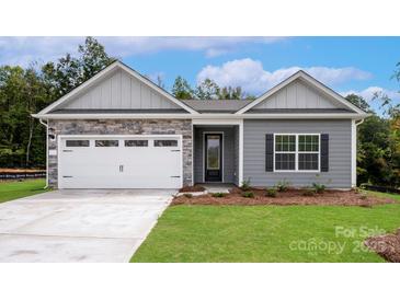 Charming single-story home with stone accents, gray siding, white garage door, and well-manicured lawn at 7121 Jerimoth Dr, Charlotte, NC 28215