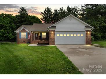 Charming brick home with a two-car garage and manicured lawn at sunset at 112 Chasse Ct, Cleveland, NC 27013