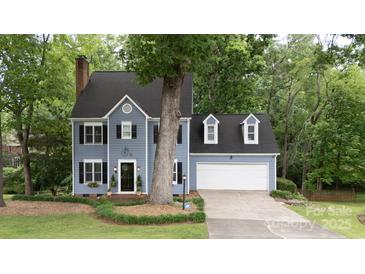Charming two-story home with blue siding, black shutters, and a well-manicured lawn, offering classic curb appeal at 211 Southfork Dr, Belmont, NC 28012
