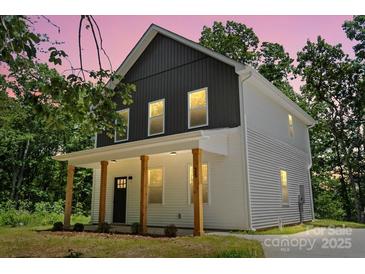 Charming two-story home boasts a welcoming front porch with wood columns and a modern two-tone facade at 25 Mickley Ave, Bessemer City, NC 28016