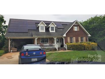 Charming two-story brick home with solar panels and welcoming front porch, ready for modern living at 4239 Saquache Dr, Charlotte, NC 28269