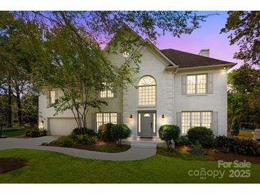 Stunning two-story white brick home with lush landscaping and a welcoming front entrance at 4622 Cotton Creek Dr, Charlotte, NC 28226