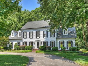 Stately two-story home with black shutters, mature landscaping and a curved driveway at 5308 Sunningdale Dr, Charlotte, NC 28277