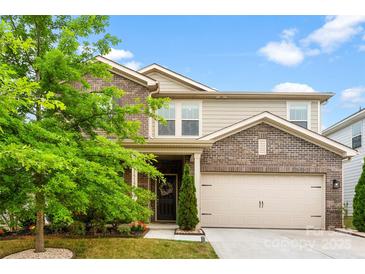 Charming two-story home featuring a mix of brick and siding, complemented by a well-manicured lawn and mature landscaping at 11518 Solstice Way, Huntersville, NC 28078