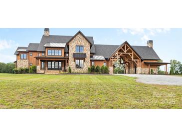 Stunning stone and wood exterior home with a porte-cochère and meticulously manicured lawn at 1822 Irby Rd, Monroe, NC 28112
