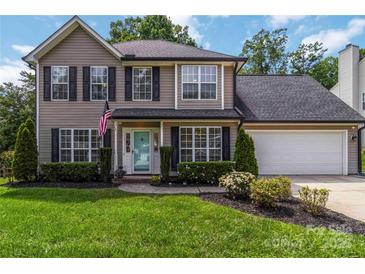 Charming two-story home with a well-manicured lawn, blue door, and an attached two-car garage at 204 Pebble Creek Xing, Fort Mill, SC 29715