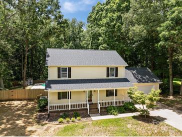 Two-story house features a charming front porch, mature trees, and a partially fenced backyard with an in-ground pool at 219 Proctor Dr, Salisbury, NC 28147