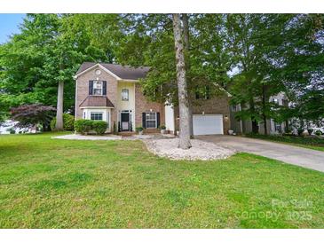 Charming two-story brick home with a well-maintained lawn and mature trees at 2426 Tory Oak Pl, Matthews, NC 28105