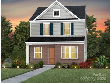 Charming two-story home with a brick facade, gray siding, and a well-manicured lawn at 3628 Pamlico St # 122, Monroe, NC 28110