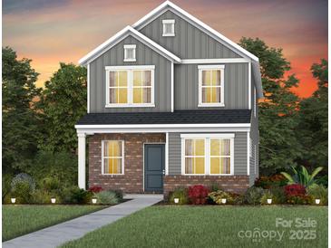 Charming two-story home featuring gray siding, brick accents, and well-manicured landscaping at 3632 Pamlico St # 120, Monroe, NC 28110