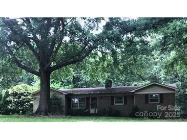 Charming single-story home with a mature tree-lined front yard and brick exterior at 3715 Vanderburg Dr, Concord, NC 28025