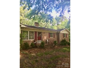 Charming single-story brick home with red shutters and a covered front porch at 3715 Vanderburg Dr, Concord, NC 28025