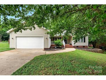 Charming one-story home featuring a well-maintained lawn and attached two-car garage at 605 Beavers Cove Nw Ln # 15, Concord, NC 28027
