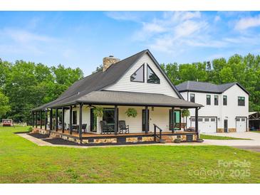 Charming white farmhouse with a sprawling front porch and black accents, surrounded by a lush green lawn at 930 Hawley Rd, McConnells, SC 29726