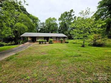 Charming single-story brick home with a carport and mature trees, offering a serene setting at 1105 Stanton Dr, Shelby, NC 28150