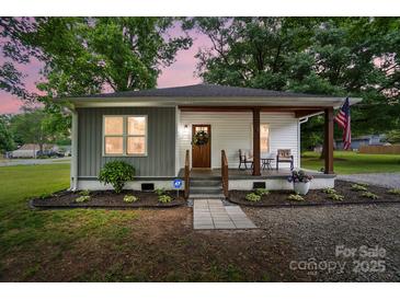 Charming home featuring a welcoming front porch, fresh landscaping, and a mix of modern and traditional design elements at 118 Globe St, Mount Holly, NC 28120