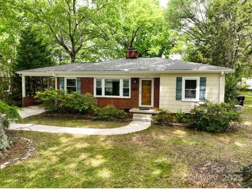 Charming single-story home with a brick facade, light siding, well-maintained lawn and beautiful, mature landscaping at 118 Marshdale Sw Ave, Concord, NC 28025