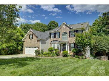 Charming two-story brick home with well-manicured lawn and lush landscaping at 12125 Mountainside Ln, Charlotte, NC 28278