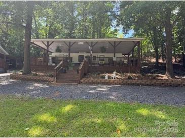 Charming covered porch home surrounded by lush trees offering shade and privacy at 146 Trivette Trl, Mount Gilead, NC 27306