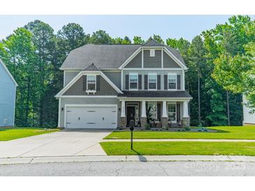 Charming two-story home featuring a well-manicured lawn and an attached two-car garage at 2714 Woodlands Creek Dr, Monroe, NC 28110