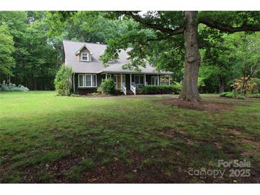Charming home with a covered front porch and mature trees in a beautiful landscaped yard at 344 Lucas Rd, Star, NC 27356