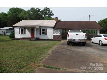 Charming single-Gathering home with a metal roof, carport, and mature trees at 5004 King Wilkinson Rd, Denver, NC 28037