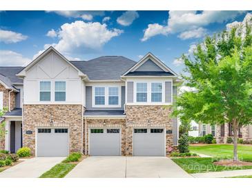 Charming townhome with stone accents, gray siding, and well-maintained landscaping, offering inviting curb appeal at 5836 Clan Maclaine Dr, Charlotte, NC 28278