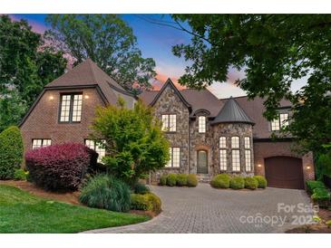 Stunning stone and brick home with manicured landscaping and a circular driveway at 5915 Vidal Ln, Charlotte, NC 28226