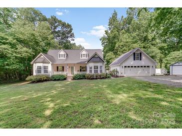 Charming home with a lush front yard, a welcoming porch, and a detached garage at 592 Woodcrest Dr, Gastonia, NC 28056