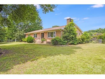 Charming brick home with a well-manicured lawn and mature trees, creating a peaceful curb appeal at 6300 Mount Pleasant S Rd, Concord, NC 28025