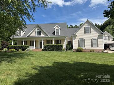 Charming home featuring a covered front porch, lush lawn, and mature landscaping at 6409 Barkley Farm Rd, Huntersville, NC 28078