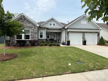 Charming home with stone accents, two-car garage and meticulously maintained lawn at 7057 Kingfisher Way, Belmont, NC 28012