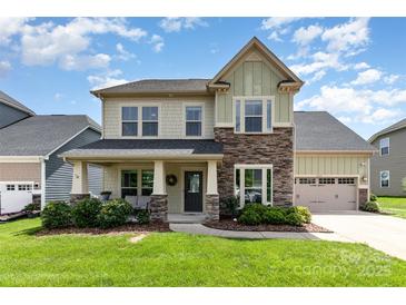 Charming two-story home with stone accents, a covered front porch, and well-manicured landscaping at 8829 Keller Ct, Huntersville, NC 28078