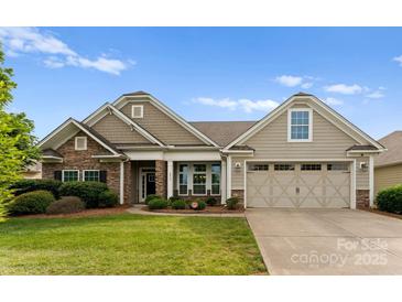 Charming single-Gathering home with stone accents, neutral siding, manicured lawn, and a two-car garage at 8830 Artesa Mill Ln, Charlotte, NC 28214