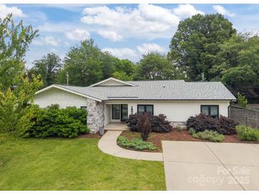 Charming single-story home featuring stone accents, fresh landscaping, and a well-maintained front yard at 1207 Lakedell Dr, Charlotte, NC 28215