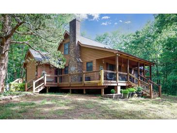 Inviting two-story home with a cozy covered porch, brick chimney, and lush green surroundings at 1371 Hawks Nest Rd, York, SC 29745