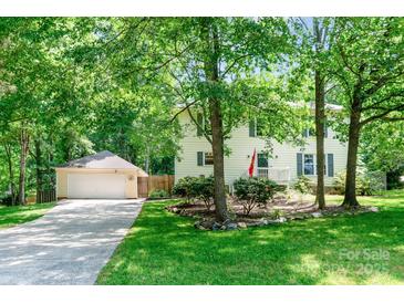 Charming home with mature trees, attached garage, and well-manicured lawn at 1739 Lesa Lin Dr, Monroe, NC 28112