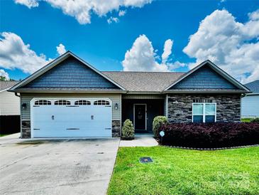 Charming single-story home with stone accents, a manicured lawn, and an attached two-car garage at 2021 Chantilly Ln, Salisbury, NC 28146