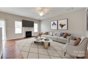 Bright living room with fireplace, ceiling fan, modern decor and stylish neutral color palette at 2169 Shady Pond Dr, Clover, SC 29710