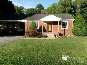 Charming brick home with a well-manicured lawn, carport, and inviting front porch at 2357 28Th Ne St, Hickory, NC 28601