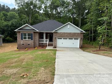Charming brick home with a well-manicured lawn, attached garage, and inviting front porch at 2915 Noritake Trl # 71, Albemarle, NC 28001