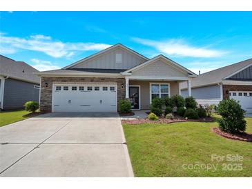 Charming single-story home with a two car garage and a well-manicured front yard under a blue sky at 4243 Merrivale Dr, Lancaster, SC 29720