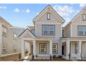 Charming two-story home with gray siding, white trim, covered entry, and manicured landscaping at 5004 Cherry Gum Ct # 43, Matthews, NC 28105