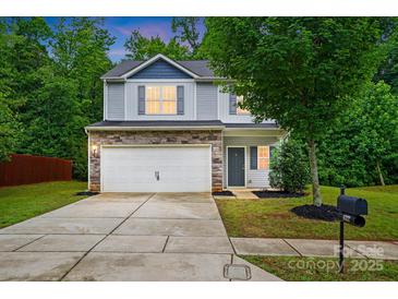 Charming two-story home boasts stone accents, a two-car garage, and a well-maintained front yard at 6322 Sydney Mae Ln, Charlotte, NC 28262