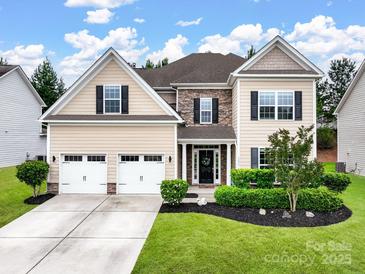 Charming two-story home featuring a well-manicured lawn, a two-car garage, and a welcoming front entrance at 1033 Crawford Dr, Lancaster, SC 29720