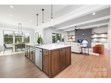 Bright, open kitchen with island, modern appliances, and seamless flow to dining and living areas at 111 Monbo Meadows Ln, Statesville, NC 28677
