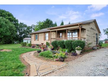 Charming single-story home with a stone walkway and lush landscaping at 112 Gays Chapel Rd, Statesville, NC 28625