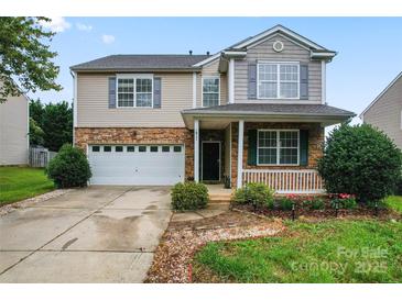 Charming two-story home featuring a stone facade, attached garage, well-manicured lawn, and welcoming front porch at 1911 Savannah Hills Dr, Matthews, NC 28105