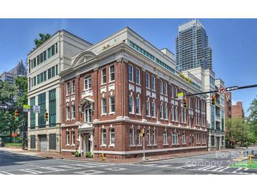 Beautiful multi-story brick building featuring white trim, large windows, and prime corner lot placement near downtown at 229 N Church St # 204, Charlotte, NC 28202