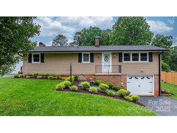 Charming single-story home featuring lush landscaping and a welcoming front entrance at 2401 Hillside Dr, Newton, NC 28658